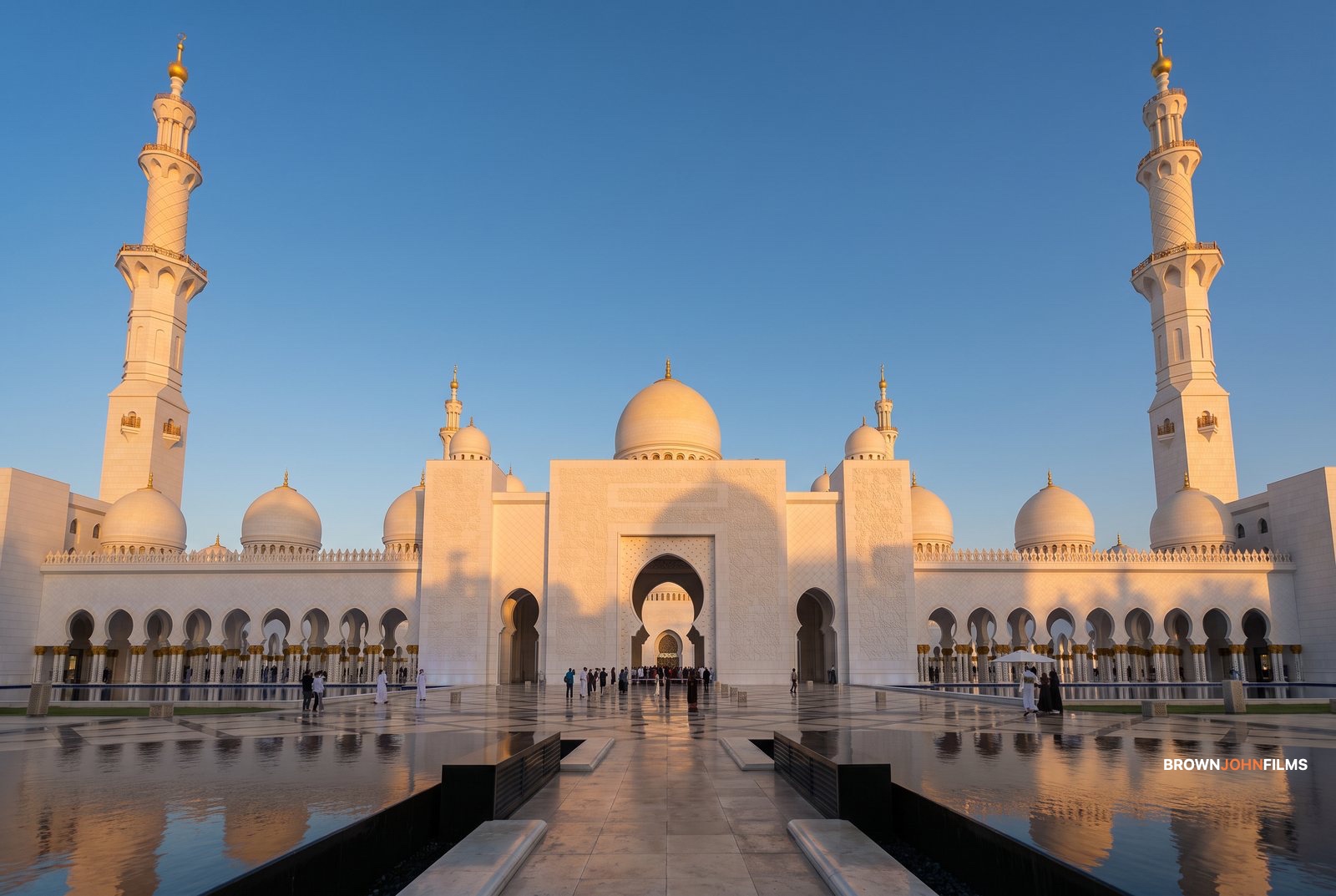 White marble mosque with domes and minarets in evening light