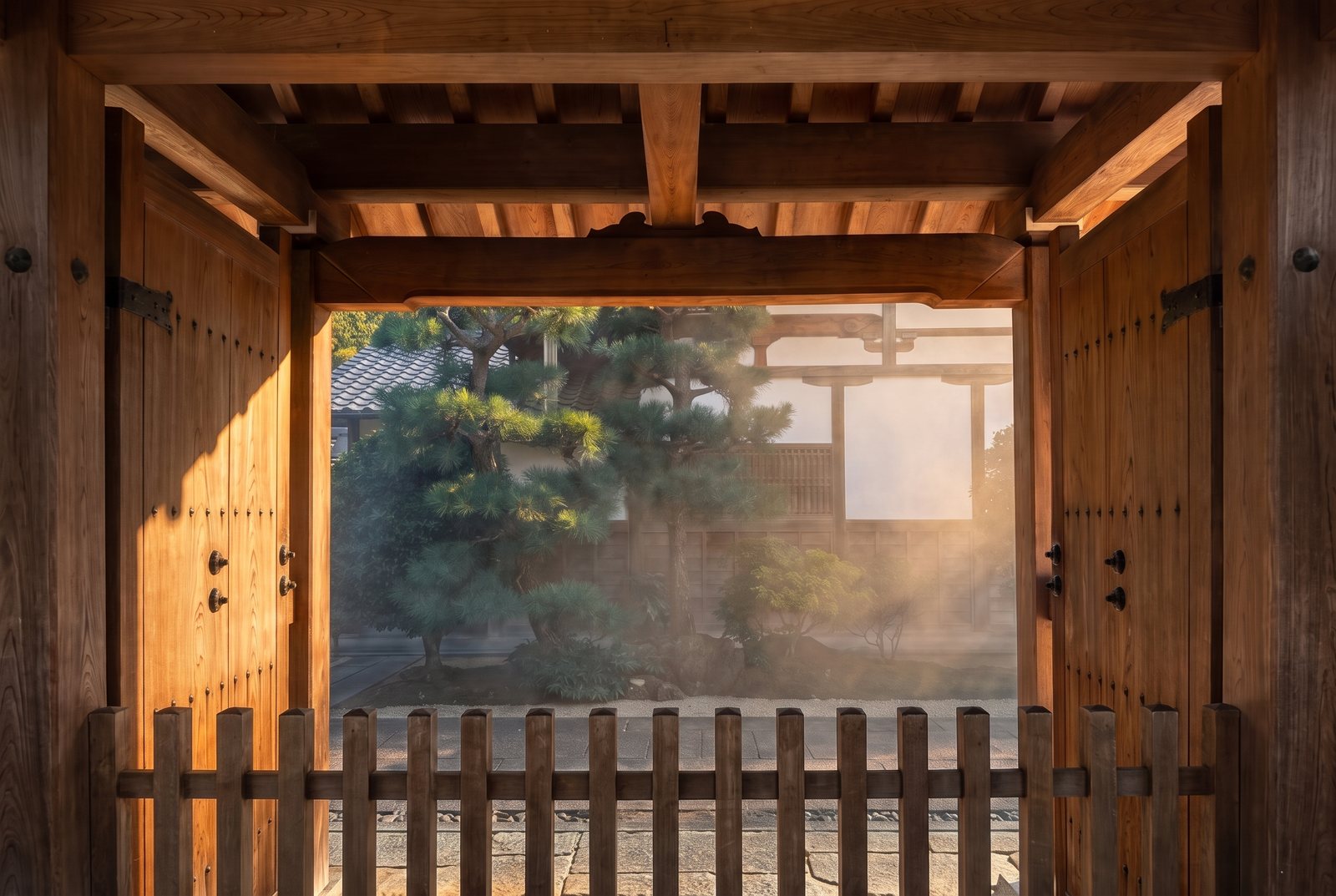 Wooden gateway looking through to a misty pine garden