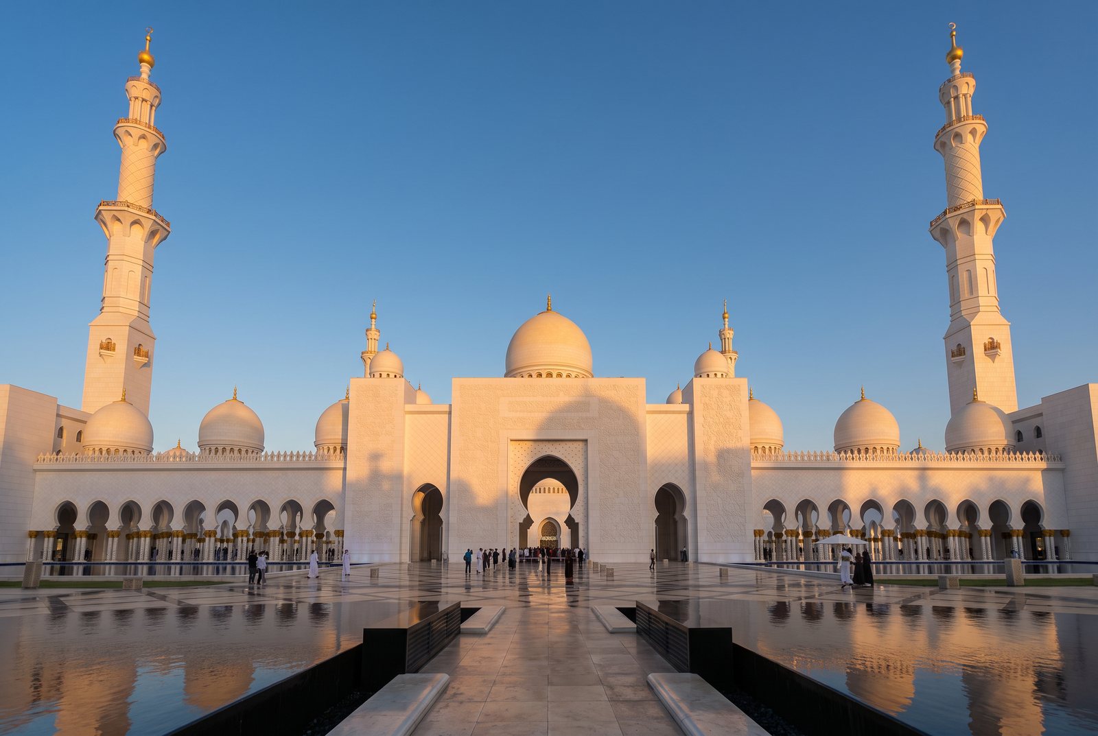 White marble mosque with domes and minarets in evening light
