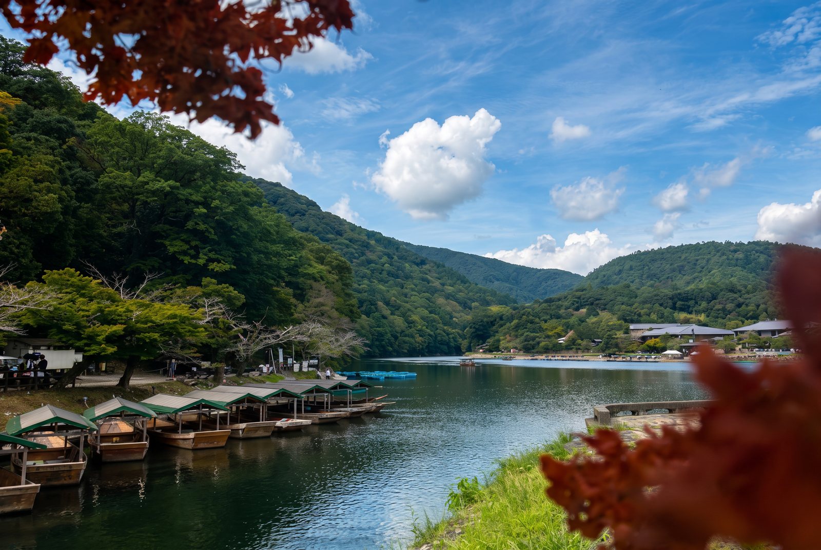 River valley of wooded hills with moored boats under blue sky